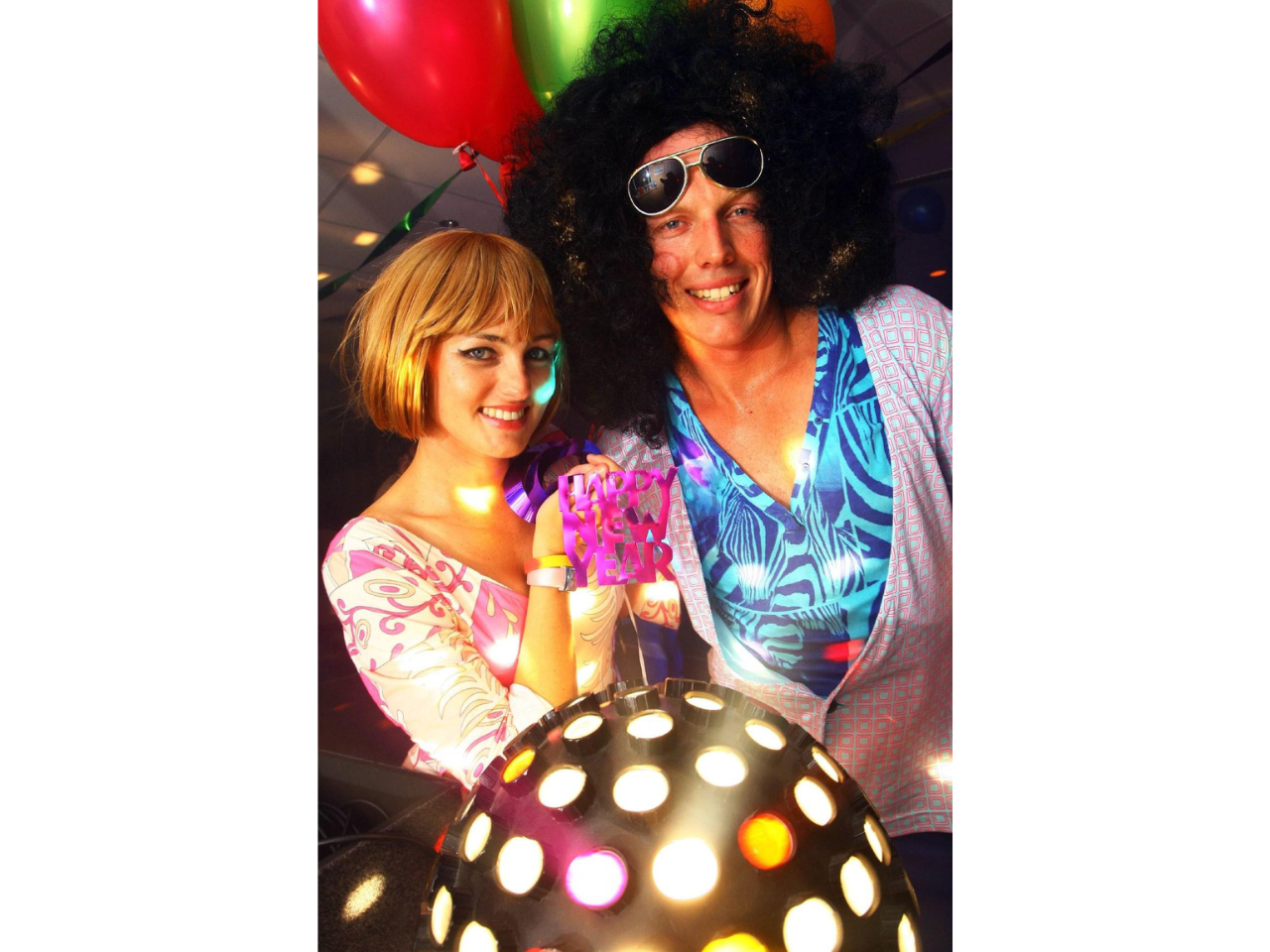 Image of male and female dressed in 60-70s disco attire